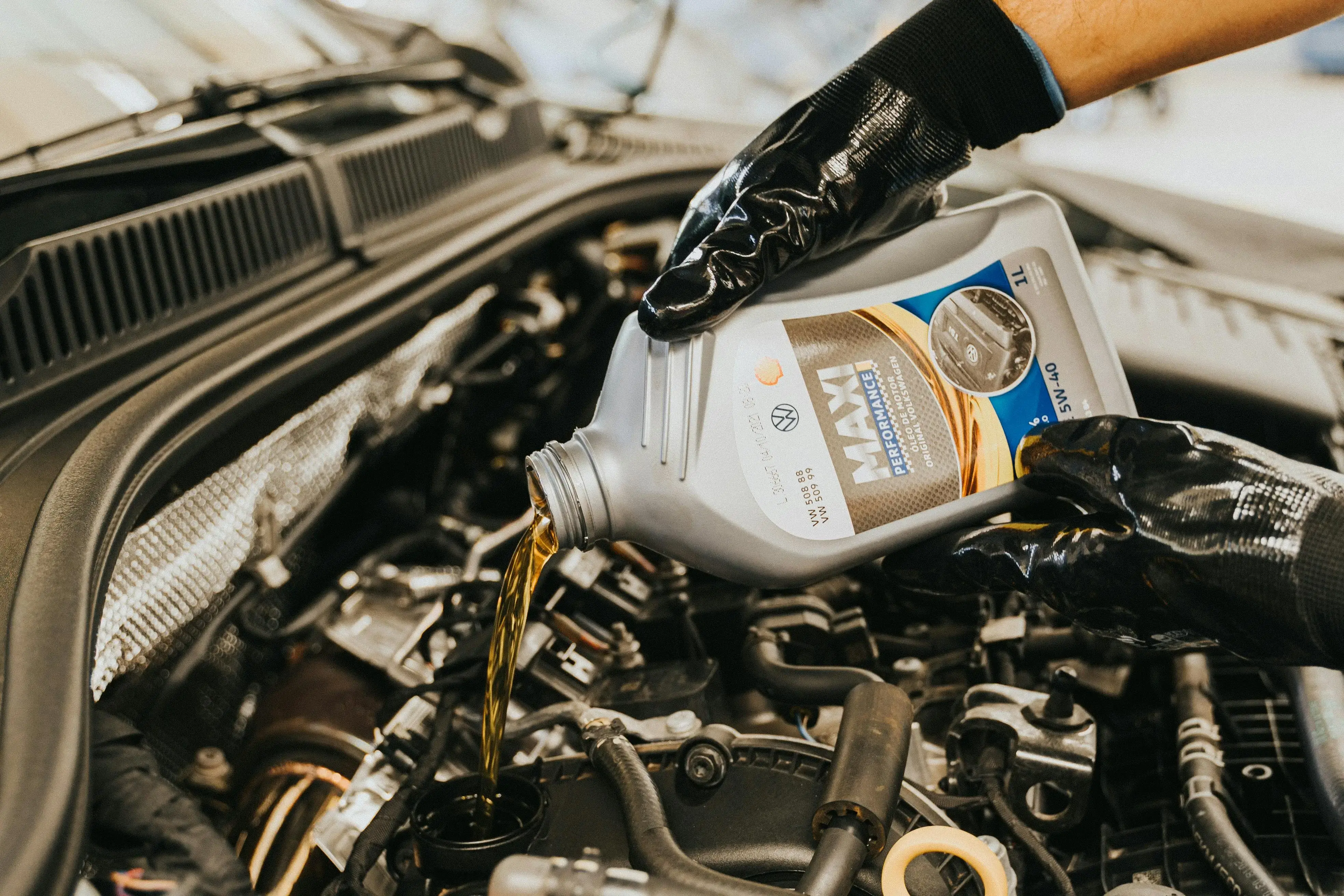 Hands Pouring Oil to Engine